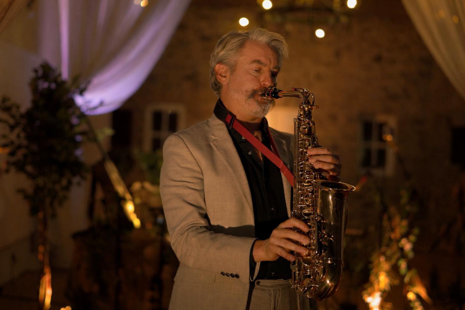 Thunderclap Murphy performing with saxophone in a warm-lit stone room