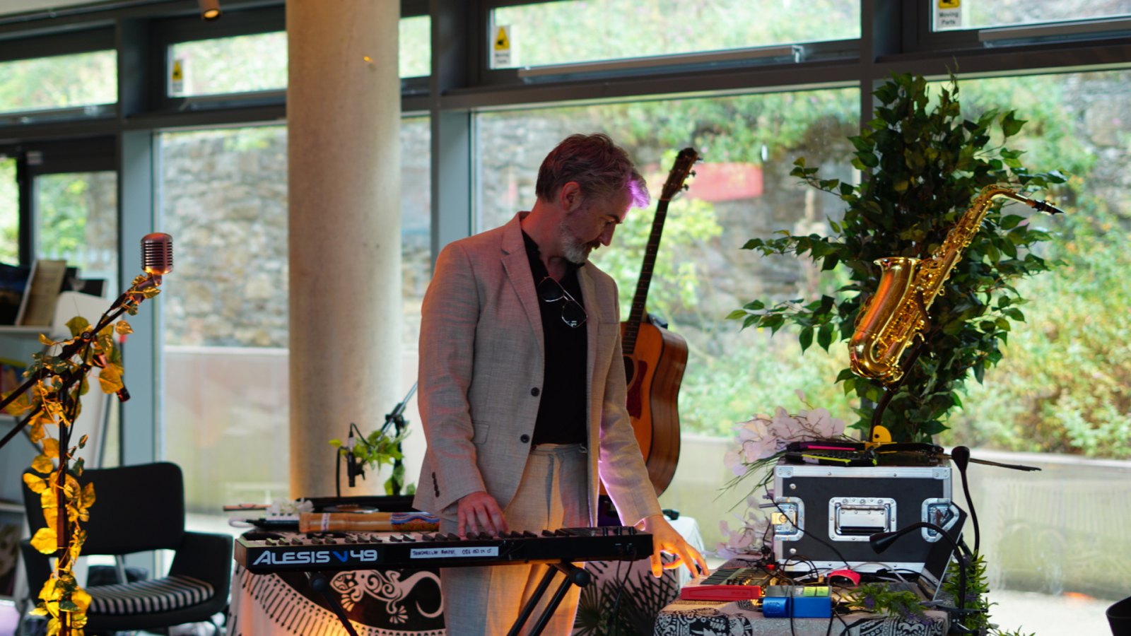 Thunderclap Murphy playing keyboard at the instrument table in Wexford Town Library, saxophone and guitar standing behind.