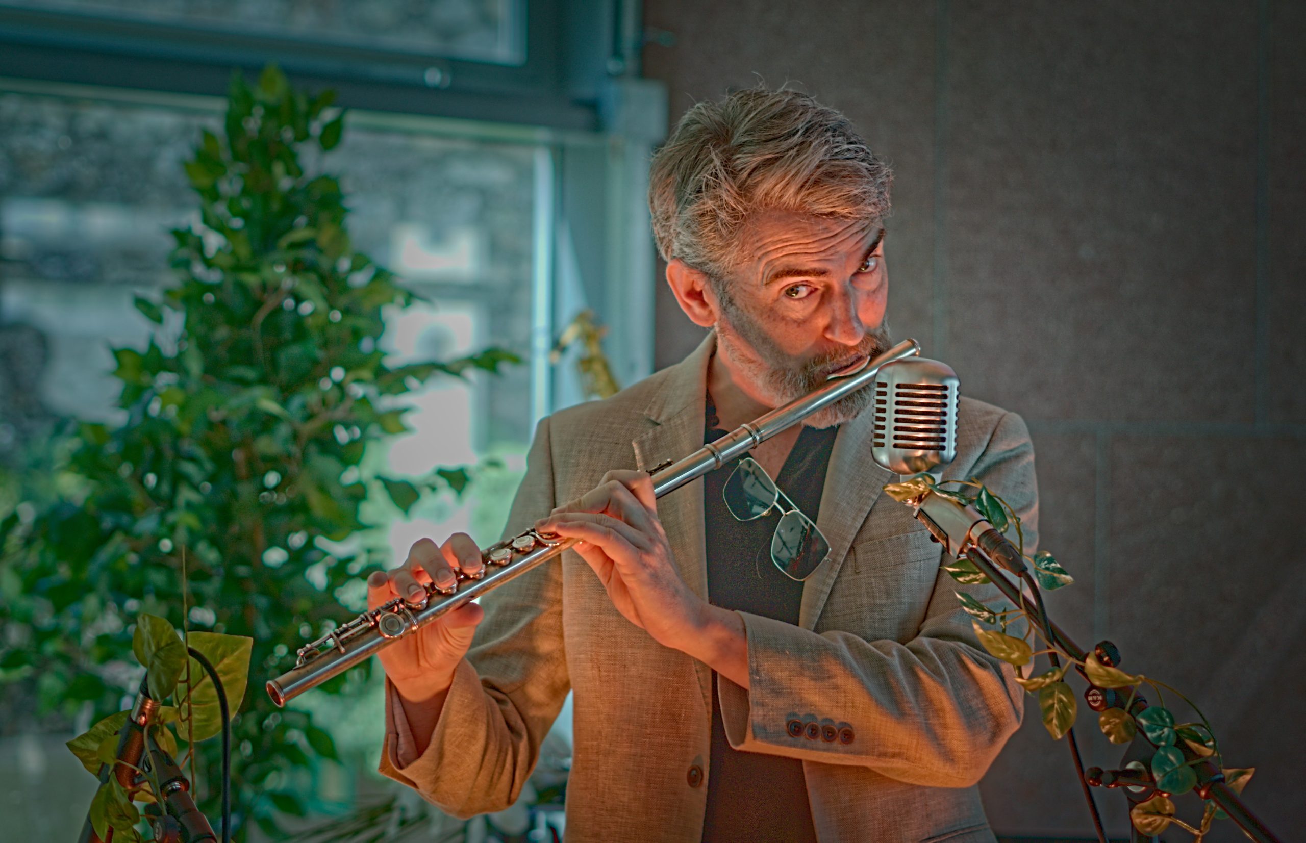 Thunderclap Murphy playing flute into a vintage ribbon microphone in the library events room.